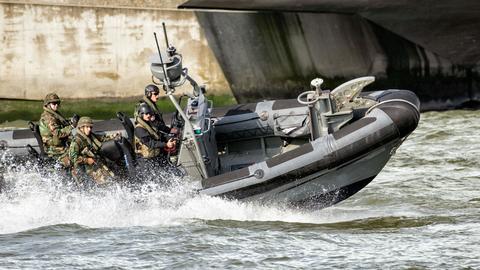 Military men navigating on a speed boat, monitoring coastal areas