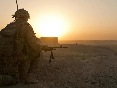 Soldier in position in desert-like terrain