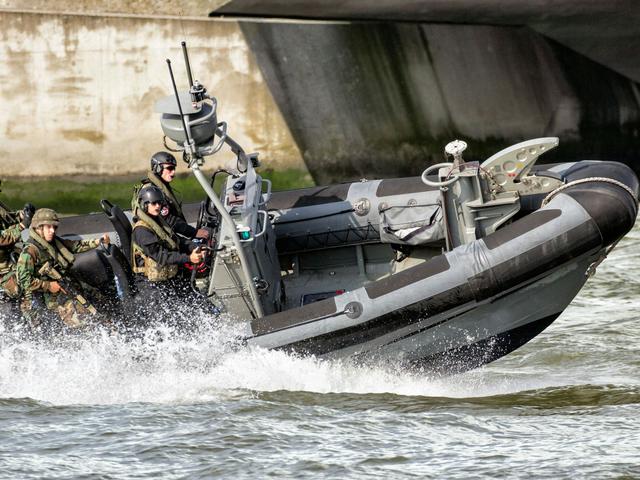 Military men navigating on a speed boat, monitoring coastal areas