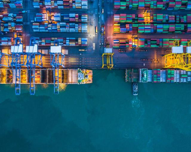Overhead perspective of a container ship loaded with various cargo containers, showcasing maritime logistics. 