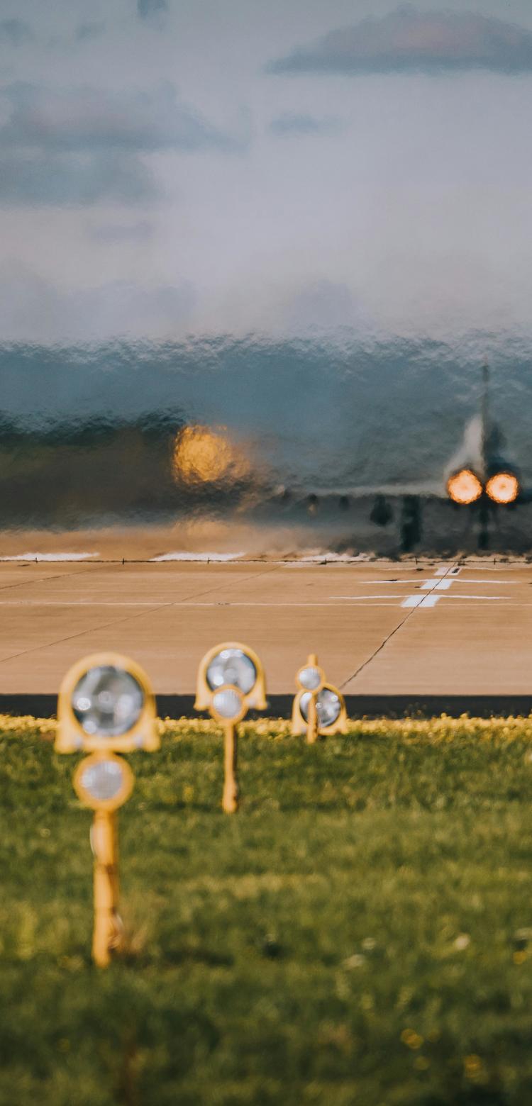 Starting airplane on a runway (view from behind)