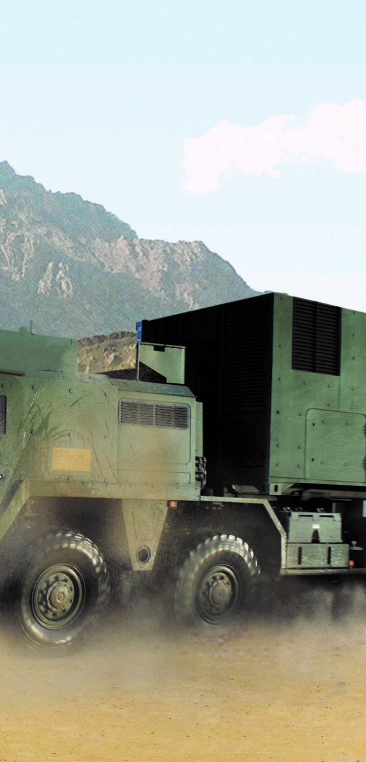 Close-up of a moving ballistic protected truck loaded with a ballistic protected TransProtec container. A barren hilly landscape can be seen in the background.