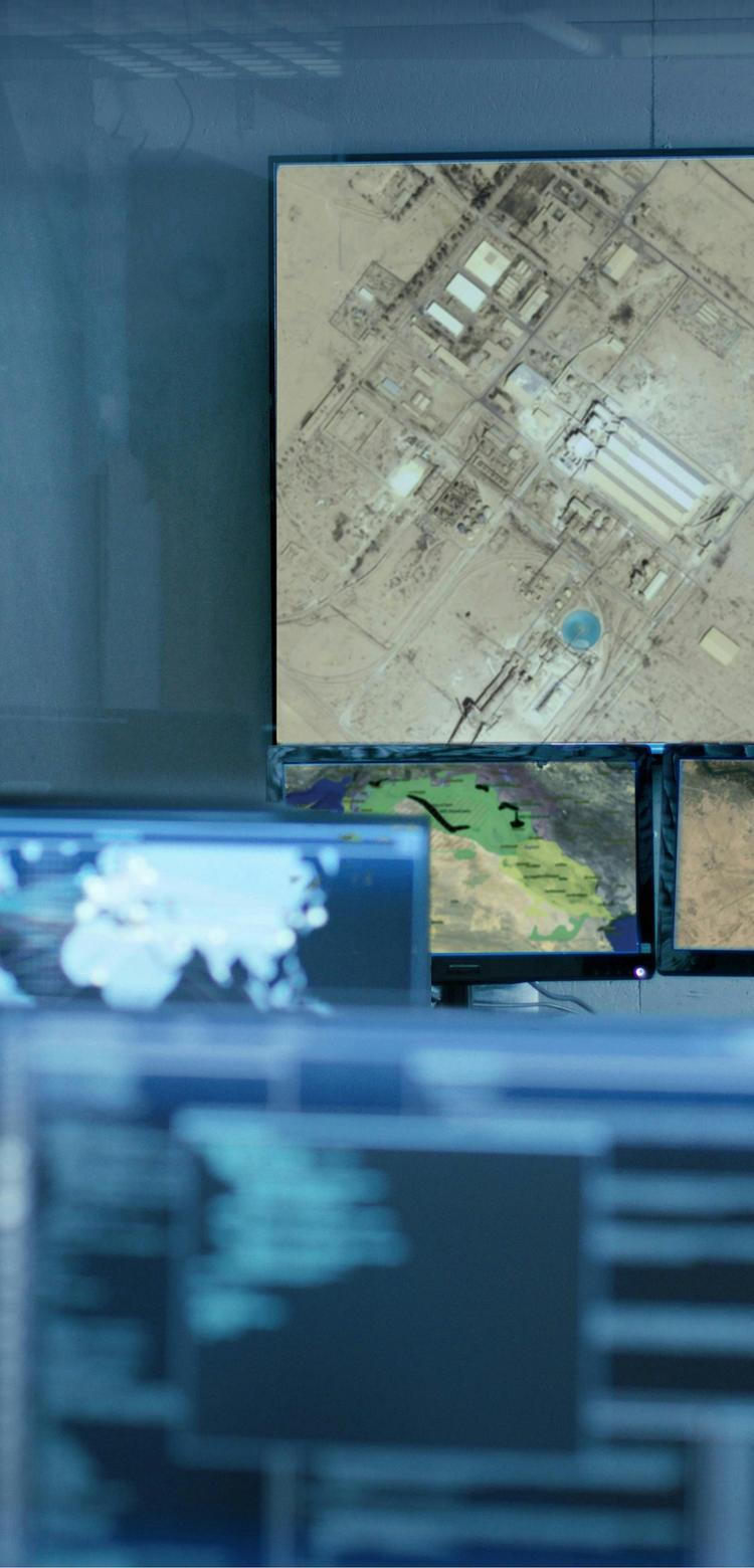 Controller collaborating on computer screens in a command centre, focused on their tasks.