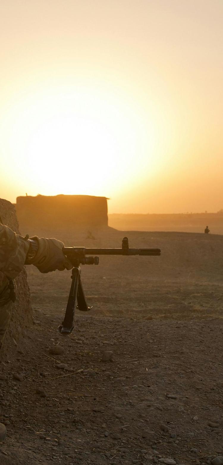 Soldier in position in desert-like terrain