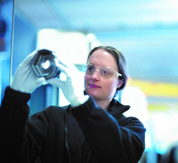A woman looking through a screw nut