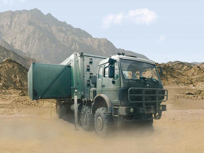 An extended 1:3 container-based mobile command post on a truck within the dessert